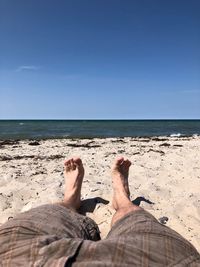 Low section of person relaxing on beach