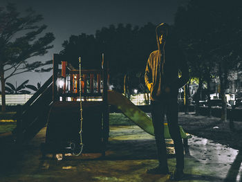 Man standing in park against sky at night