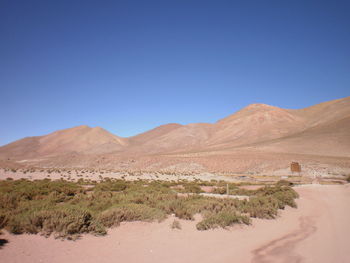Scenic view of mountains against blue sky