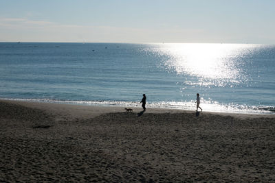 People on beach against sky