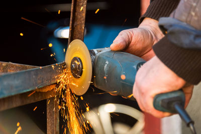 Midsection of man working on metal structure