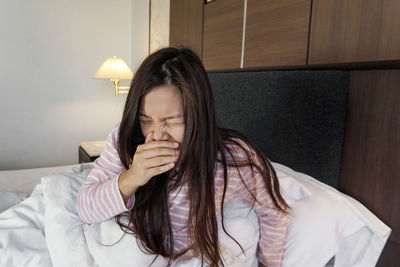 Asian woman wearing mask on the bed.