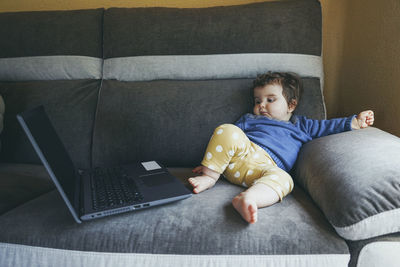 Boy sitting on sofa at home