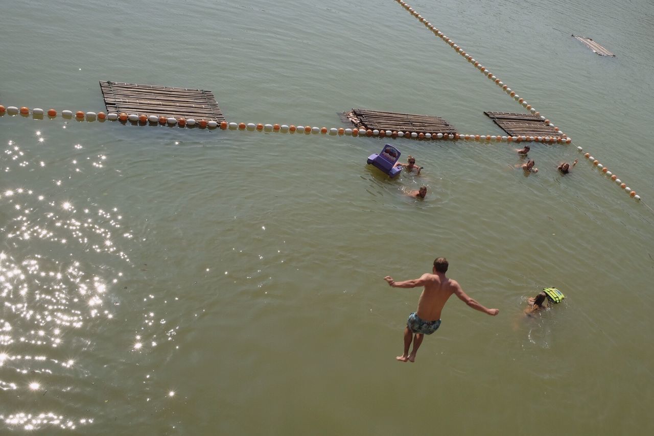 HIGH ANGLE VIEW OF TWO PEOPLE SWIMMING IN RIVER