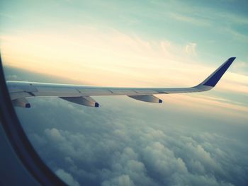 Cropped image of airplane flying over clouds