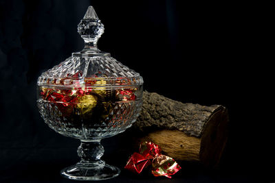 Close-up of wine glass on table against black background