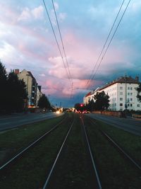 Railroad tracks against cloudy sky