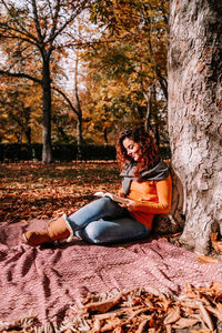 Woman sitting on street during autumn