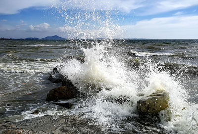 Close-up of sea waves splashing against sky