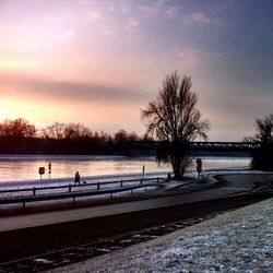 Scenic view of river against sky at sunset