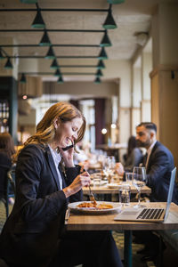 Woman sitting on table at restaurant