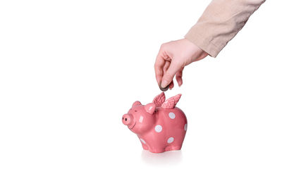 Close-up of hand holding ring against white background
