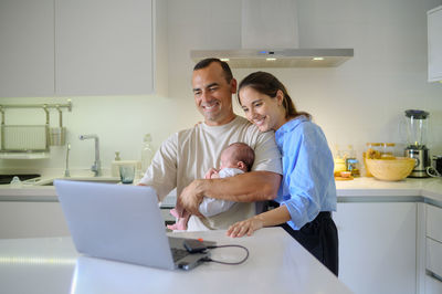 Portrait of woman using laptop at home