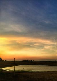 Scenic view of silhouette field against sky during sunset