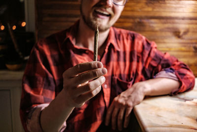 Close-up of man holding marijuana joint