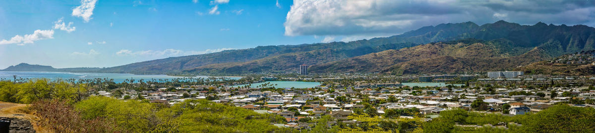 Panoramic view of townscape by mountains against sky