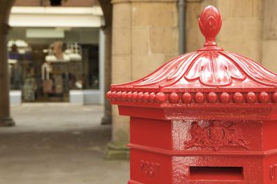 Close-up of red metallic post box in city