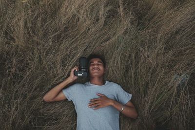 Man with camera lying down on hay