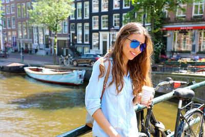 Young woman with sunglasses on boat in city
