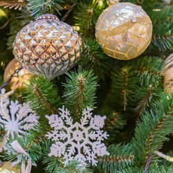 Close up of christmas tree decorated with gold and white balls and snowflake. new year background