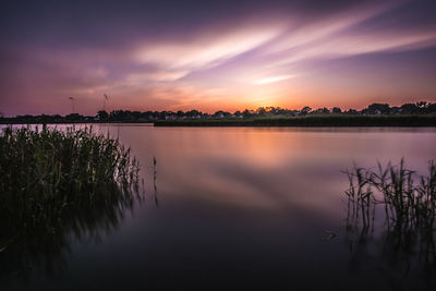 Scenic view of lake against romantic sky at sunset