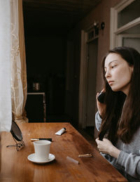 Portrait of young woman sitting on table