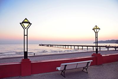 Empty street light on beach against clear sky