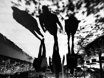 Rear view of silhouette people walking on zebra crossing