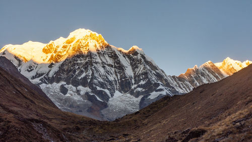 Scenic view of snowcapped mountains against clear sky