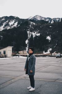 Young man standing on field against sky