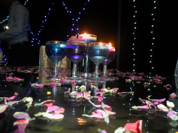 View of wine glasses on table at night