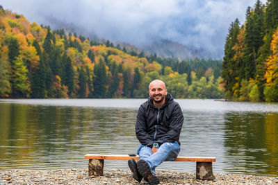 Portrait of man standing by lake