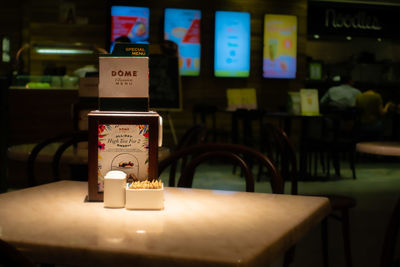 Close-up of illuminated sign on table in restaurant