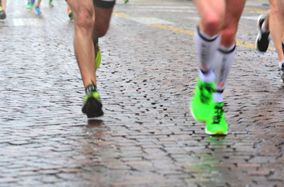 Low section of people running on street