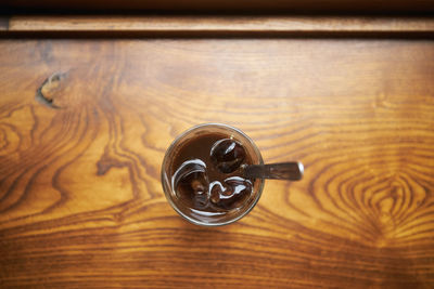 Close-up of glass of vietnamese iced coffee on wooden table. selective focus on ice cubes. 