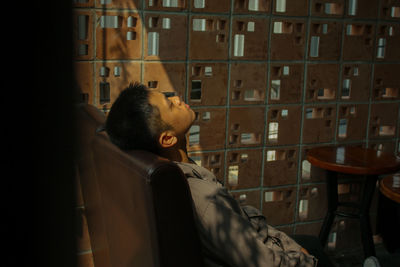 Young man resting on chair at cafe