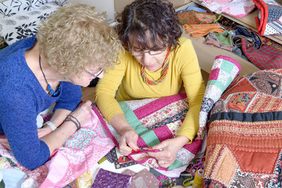 Owner with colleague looking at fabric in shop