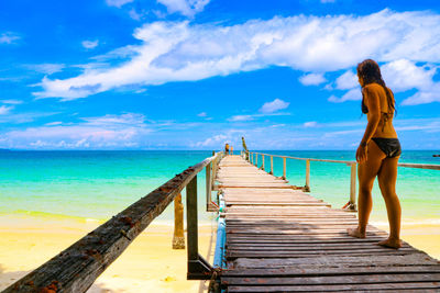 Rear view of woman standing on pier