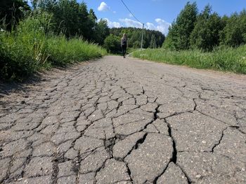 Man walking on dirt road amidst trees