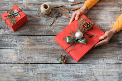 High angle view of woman with gift during christmas on table