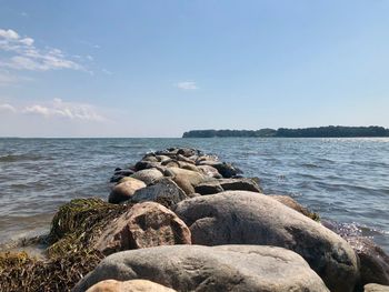 Rocks on sea shore against sky