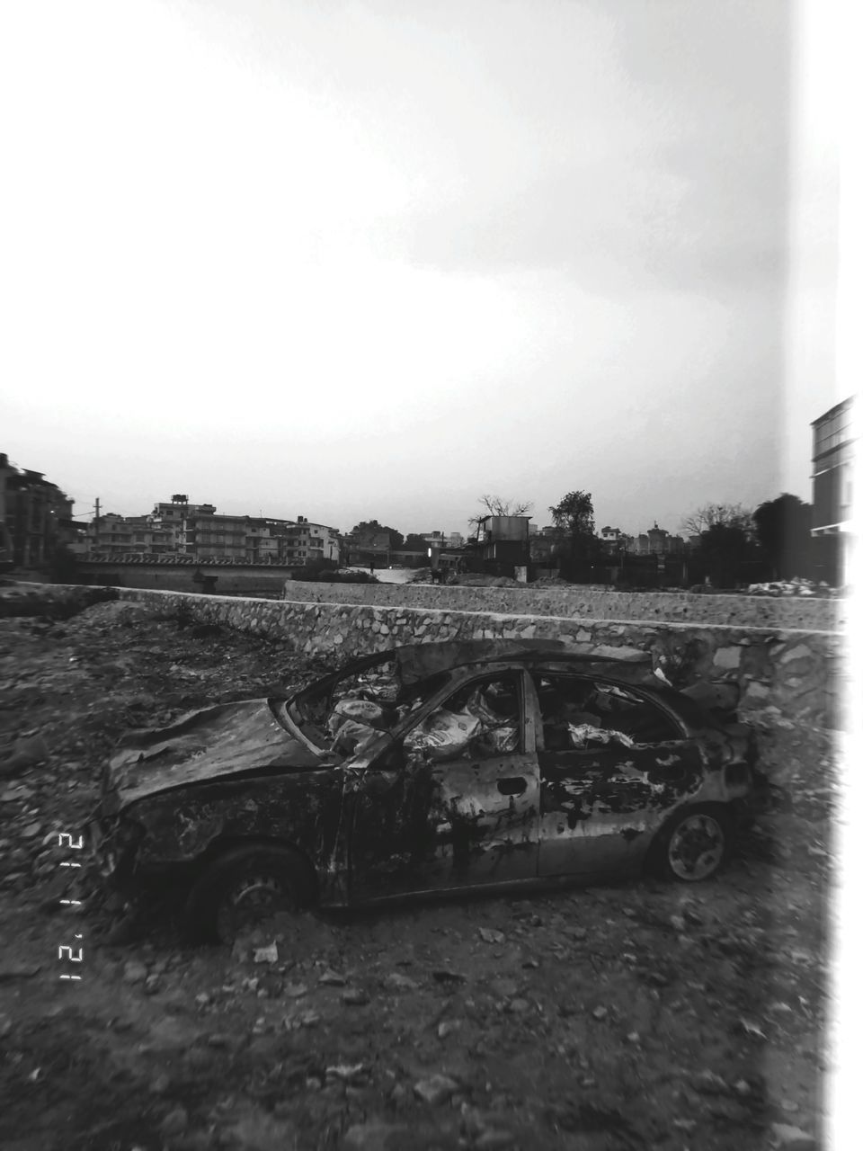 ABANDONED CAR ON ROAD AGAINST SKY