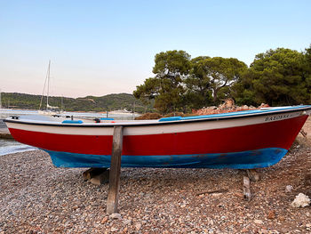 Sailboats moored on beach against clear blue sky