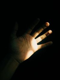 Close-up of human hand in darkroom