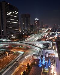 High angle view of illuminated street amidst buildings at night