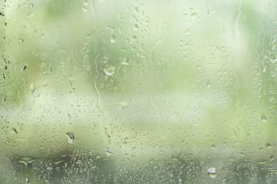 Full frame shot of wet glass window in rainy season