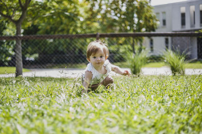 Portrait of baby playing on field