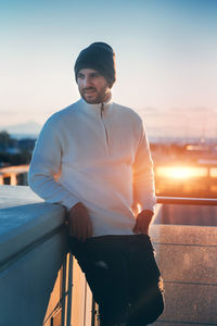 Portrait of young man standing against sky during sunset