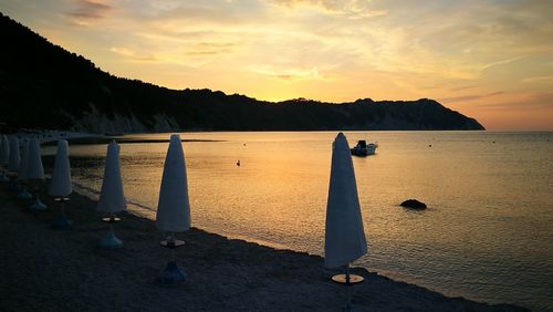 People on beach against sky during sunset