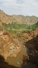 High angle view of river and mountains against sky